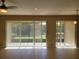Bright living room features tile floors, neutral walls, and sliding glass doors to an outdoor area at 6240 Miramonte Dr # 102, Orlando, FL 32835