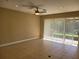 Bright living room featuring neutral walls, tiled floors, ceiling fan, and sliding glass doors to the patio at 6240 Miramonte Dr # 102, Orlando, FL 32835