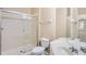 Bathroom with a shower with sliding glass doors, white toilet and white sink vanity at 6402 Cava Alta Dr # 107, Orlando, FL 32835
