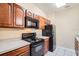 Kitchen with dark wood cabinets, black appliances and light countertops at 6402 Cava Alta Dr # 107, Orlando, FL 32835