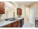 Open kitchen with stainless steel sink and black dishwasher looking into the living and dining rooms at 6402 Cava Alta Dr # 107, Orlando, FL 32835