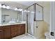 Well-lit bathroom featuring a glass shower, modern vanity with dual sinks, and a ceramic tile floor at 6524 Calamondin Dr, Winter Garden, FL 34787