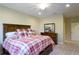 Bedroom featuring wood furniture, a comfortable plaid bedspread, and neutral walls at 6524 Calamondin Dr, Winter Garden, FL 34787
