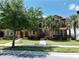 Charming townhome exterior featuring lush landscaping, sidewalk and a beautiful outdoor space with palm trees at 6524 Calamondin Dr, Winter Garden, FL 34787