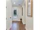 Hallway featuring hardwood floors, a modern light fixture and a white door with glass panel at 6524 Calamondin Dr, Winter Garden, FL 34787