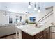 Bright kitchen with a large granite island, stainless sink, pendant lighting, and staircase access at 6524 Calamondin Dr, Winter Garden, FL 34787