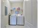 Well-organized laundry room featuring a washer, dryer, storage shelf and laundry room themed decor at 6524 Calamondin Dr, Winter Garden, FL 34787