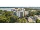Stunning aerial view of the building, surrounded by lush greenery, showcasing its architectural design and proximity to the lake at 690 Osceola Ave # 502, Winter Park, FL 32789