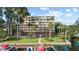 View of multi story condo building with waterfront access, dock, and lush tropical landscaping at 690 Osceola Ave # 502, Winter Park, FL 32789