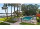 Elevated view of a community pool with lush tropical landscaping with a lake view at 690 Osceola Ave # 502, Winter Park, FL 32789