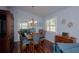 Bright dining room features wood floors, large window, chandelier and dining table with seating for six at 735 Oak Ter, Orange City, FL 32763