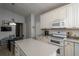Spacious kitchen with island and dining area, featuring white cabinetry and stainless steel appliances at 735 Oak Ter, Orange City, FL 32763