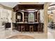 Home bar with dark wood cabinetry, bar stools, and ample shelving is perfect for entertaining guests at 8590 Apache Trl, Kissimmee, FL 34747