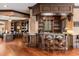 Luxurious home bar with rich wood cabinetry, marble countertop, and seating for entertaining guests at 8590 Apache Trl, Kissimmee, FL 34747