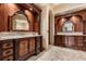 Stunning primary bath boasts dual vanities, detailed wood accents, marble floors, and a walk-in shower at 8590 Apache Trl, Kissimmee, FL 34747
