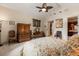 Bright bedroom with a ceiling fan, vanity, tapestry and a view into the attached bathroom at 8590 Apache Trl, Kissimmee, FL 34747