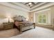 Spacious bedroom featuring a tray ceiling, a large window seat, and matching bedside tables at 8590 Apache Trl, Kissimmee, FL 34747