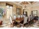 Dining room featuring a large wooden table, decorative chandelier, and view of manicured outdoor landscaping at 8590 Apache Trl, Kissimmee, FL 34747
