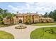 Stunning Mediterranean home with a circular driveway and ornate fountain, surrounded by lush landscaping at 8590 Apache Trl, Kissimmee, FL 34747