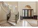 Elegant foyer features a curved staircase with wrought iron railings and arched doorways at 8590 Apache Trl, Kissimmee, FL 34747