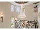 Elegant foyer with a grand chandelier, curved staircase, decorative iron railing, and ornate sconces at 8590 Apache Trl, Kissimmee, FL 34747