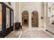 Elegant foyer features arched doorways, marble floors, and intricate ironwork on the front door at 8590 Apache Trl, Kissimmee, FL 34747
