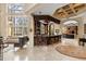 Elegant foyer with a wet bar, marble flooring, and an archway leading to a grand living space at 8590 Apache Trl, Kissimmee, FL 34747