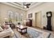 Comfortable living room features large arched windows, coffered ceilings, a ceiling fan, and a vintage grandfather clock at 8590 Apache Trl, Kissimmee, FL 34747