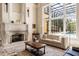 Bright living room with fireplace, large windows, and elegant furnishings offers a cozy and stylish space at 8590 Apache Trl, Kissimmee, FL 34747