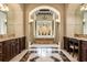 Grand main bathroom with marble floors, dual vanities, and a luxurious soaking tub set against a private courtyard at 8590 Apache Trl, Kissimmee, FL 34747
