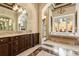 Elegant main bathroom showcasing marble countertops, custom cabinetry, and a soaking tub with a courtyard view at 8590 Apache Trl, Kissimmee, FL 34747