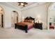 Spacious main bedroom suite with a tray ceiling, complemented by an arched entryway for added architectural interest at 8590 Apache Trl, Kissimmee, FL 34747