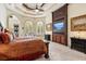 Well-appointed main bedroom with a tray ceiling, ceiling fan, large windows, and custom millwork at 8590 Apache Trl, Kissimmee, FL 34747