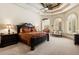 Spacious main bedroom with a tray ceiling, ceiling fan, large windows, and an arched entry to a sitting room at 8590 Apache Trl, Kissimmee, FL 34747