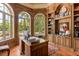 Executive office with custom wood built-ins, hardwood floors, and large windows with a beautiful yard view at 8590 Apache Trl, Kissimmee, FL 34747