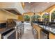 A well-equipped outdoor kitchen features modern appliances and a sleek granite countertop adjacent to the pool at 8590 Apache Trl, Kissimmee, FL 34747