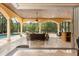 Spacious screened-in patio featuring travertine floors, lounge seating, and views of the pool at 8590 Apache Trl, Kissimmee, FL 34747