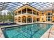 Beautiful backyard pool with spa, surrounded by travertine decking and enclosed within a large screened structure at 8590 Apache Trl, Kissimmee, FL 34747