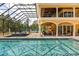 A stunning covered pool area with detailed tilework, outdoor seating, and views of the surrounding greenery at 8590 Apache Trl, Kissimmee, FL 34747