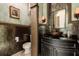 Unique powder room featuring ornate wallpaper, custom vanity, copper vessel sink, and decorative lighting at 8590 Apache Trl, Kissimmee, FL 34747