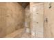 Elegant travertine shower with a built-in bench, frameless glass door, and mosaic tile accents at 8590 Apache Trl, Kissimmee, FL 34747