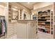 Spacious walk-in closet featuring custom shelves, drawers, and a central island with a marble countertop at 8590 Apache Trl, Kissimmee, FL 34747