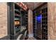 Wine cellar with custom wood racks, brick walls, and a climate-controlled cooler at 8590 Apache Trl, Kissimmee, FL 34747