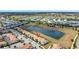 Aerial view of a residential community with townhomes nestled beside a picturesque pond at 8969 Stinger Dr, Davenport, FL 33896