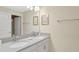 Bright bathroom with a double sink vanity, gray countertop, framed mirror, and modern fixtures at 8969 Stinger Dr, Davenport, FL 33896