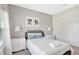 Neutral bedroom with white bedding and matching lamps on either side of the queen sized bed at 8969 Stinger Dr, Davenport, FL 33896