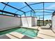 Enclosed pool area with serene water, lounge chair, and view of the lush landscape at 8969 Stinger Dr, Davenport, FL 33896