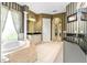 This bathroom showcases a soaking tub, vanity, striped wallpaper and archway access to other areas at 9178 Panzani Pl, Windermere, FL 34786