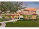 Stunning home exterior is highlighted by meticulously manicured landscaping, warm colors, and a beautiful driveway and lawn at 9178 Panzani Pl, Windermere, FL 34786