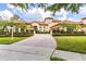 Beautiful home features a paver driveway, a meticulously maintained lawn, lush landscaping, and a well-lit two-car garage at 9178 Panzani Pl, Windermere, FL 34786